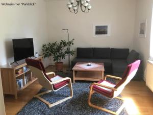 a living room with two chairs and a couch at Ferienwohnung Kastanienblick oder Parkblick, oder unser Radlerzimmer! in Ziethen