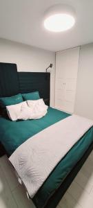 a bedroom with a large bed with green and white sheets at Apartments in Šiauliai city center in Šiauliai