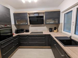 a kitchen with black cabinets and black appliances at Ferienwohnung Staeves in Sassen