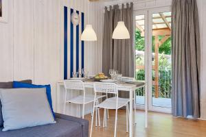 a dining room with a white table and chairs at Kompleks Wypoczynkowy Pomerania z podgrzewanym basenem 30 metrów do morza in Rewal