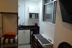 a small kitchen with a sink and a microwave at Studio no coração de Petrópolis in Petrópolis