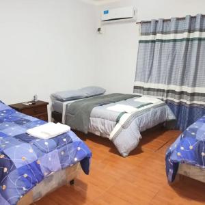 a bedroom with two twin beds and a table at Casa Martina in Tinogasta