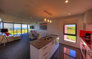 a kitchen and living room with a view of the ocean at Horizon Deluxe Apartments in Stanley