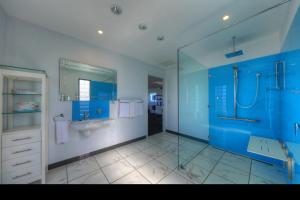 a blue bathroom with a sink and a shower at Horizon Deluxe Apartments in Stanley +16 photos