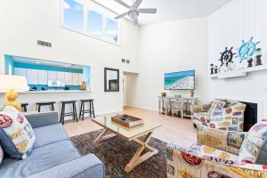 a living room with two couches and a table at Living the Dream By Beachside Management in Siesta Key