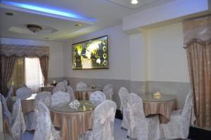 a room with tables and chairs and a painting on the wall at Al Ahrar Hotel in Dubai