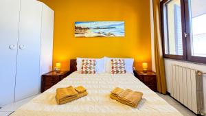 1 dormitorio con 1 cama grande y paredes amarillas en Ben House, en Santa Giusta