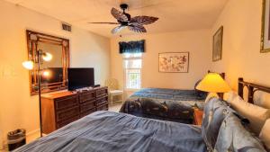 1 dormitorio con 2 camas y vestidor con espejo en Embassy 402 Condominium Condo, en South Padre Island