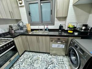 eine Küche mit Spüle und Waschmaschine in der Unterkunft Charming Luxury Apartment - New Cairo in Kairo
