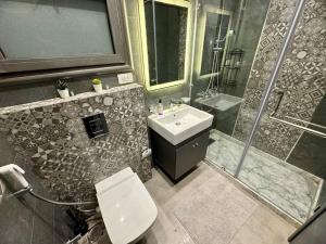 ein Badezimmer mit Waschbecken, Dusche und Toilette in der Unterkunft Charming Luxury Apartment - New Cairo in Kairo + 12 Fotos