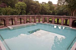 una gran piscina frente a un puente en WelcomHeritage Bal Samand Lake Palace en Jodhpur