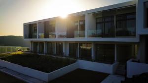 a building with the sun setting behind it at fenias luxury studios in Kallithea Halkidikis