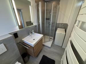 un bagno con lavandino e doccia di Birkenweg Ankerplatz I a Carolinensiel Altre 14 foto