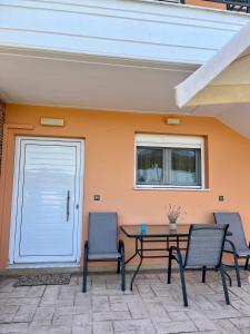 a patio with a table and chairs and a door at Aspasia Apartment in Kanali
