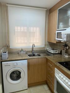 a kitchen with a washing machine and a sink at Edificio TORREMAR vistas al mar, orientación norte, Wifi y Smart-TV in Oropesa del Mar