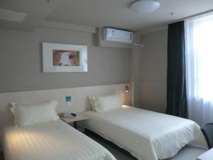 a hotel room with two beds and a window at Jinjiang Inn Linyi South Suhe Road in Linyi