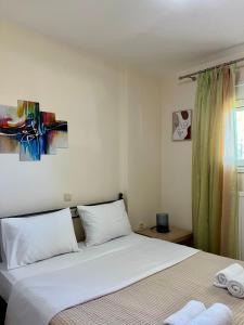 a bedroom with two beds and a painting on the wall at Aspasia Apartment in Kanali
