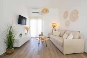 a white living room with a white couch and a table at Cerro Fine Living in Ermoupoli