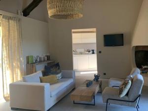 una sala de estar con un sofá y dos sillas en Villa Pieds dans l eau, en Porto Vecchio