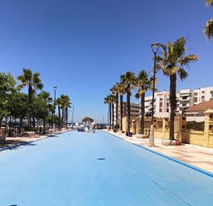 an empty street with palm trees and buildings at Estudio Taupe in Matalascañas