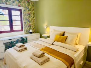 um quarto com uma cama grande com toalhas em Tranquil Hillside with Oceanview and Pool em Los Cristianos