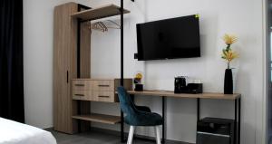 a bedroom with a desk with a tv and a chair at Frida Luxury B&B in Vietri sul Mare