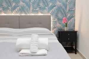 Un dormitorio con una cama con sábanas blancas y un papel pintado azul y blanco. en Alba Home Re Di Roma, en Roma