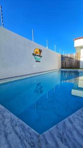 una piscina accanto a un muro bianco di Apartamento Praia Porto mais Alegre a Porto Seguro