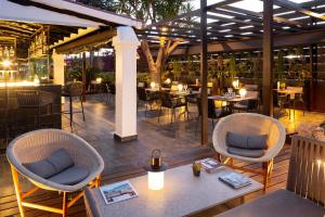 a restaurant with two chairs and tables and tables at Hotel Boutique Ses Pitreras in San Antonio Bay