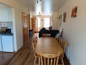 a dining room and living room with a wooden table at 4 Bed Close to Beach and Village in Enniscrone
