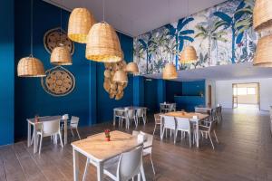 une salle à manger avec des tables et des chaises et des murs bleus dans l'établissement Bangalô Exclusivo Frente Mar Serviço incluído - Eco Resort Carneiros, à Praia dos Carneiros