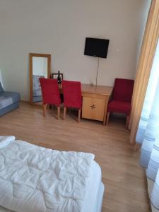 een slaapkamer met een bed en 2 stoelen en een bureau bij Jūris in Nida