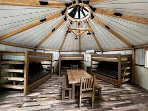 une pièce avec une table et des bancs dans une yourte dans l'établissement Cabin O' Pines - A Family Friendly Resort, à Orr