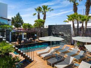a swimming pool with lounge chairs and umbrellas at Hotel Boutique Ses Pitreras in San Antonio Bay