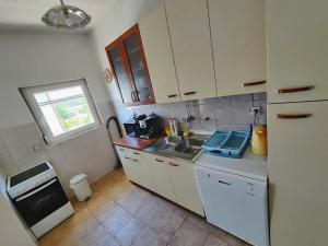 a small kitchen with a sink and a refrigerator at Apartment Travica in Posedarje