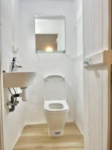 a small bathroom with a toilet and a sink at Casa Abanico in Cullera in Cullera +5 photos