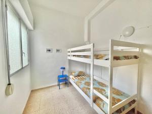 a room with two bunk beds and a blue chair at Casa Abanico in Cullera in Cullera