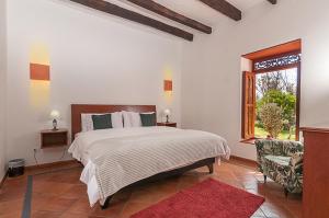 a bedroom with a large bed and a window at Hotel Marquesa de Pinares in Tibasosa