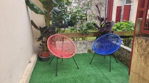 three colorful chairs sitting on a porch with plants at Duplex Dax in Dax