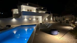 a swimming pool in front of a house at night at Casa Malìa Luxury Guest House in Luz