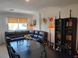 un salon avec une table et un canapé en cuir dans l'établissement Apartamento Mariona Home, à Estepona