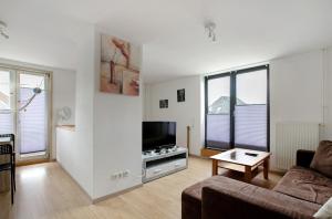 a living room with a couch and a flat screen tv at Ferienwohnung Heimathafen in Wester-Ohrstedt