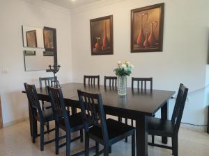 une table à manger avec des chaises et un vase de fleurs dans l'établissement Apartamento Mariona Home, à Estepona