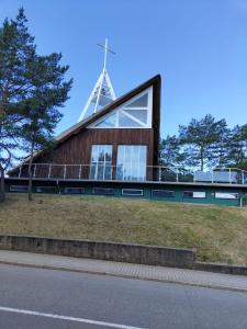 een kerk met een toren op een gebouw bij Jūris in Nida