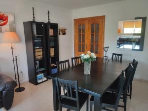 une table à manger avec des chaises et un vase de fleurs dans l'établissement Apartamento Mariona Home, à Estepona