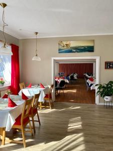 a dining room with tables and chairs in a room at MäuseScheune in Sankt Annen