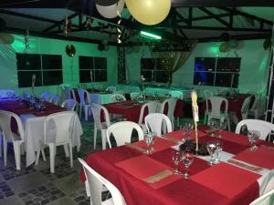 a dining room with red and white tables and chairs at Castillo Del Toro in Armenia