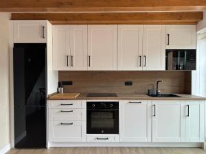a kitchen with white cabinets and a black appliance at Aire de Picos Norte in Brez +34 photos