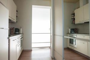 a kitchen with white cabinets and a door with a window at Spacious cozy home and sunny terrace in Nida in Neringa +17 photos