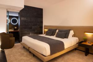 a bedroom with a large bed and a chair at Hotel Boutique Ses Pitreras in San Antonio Bay